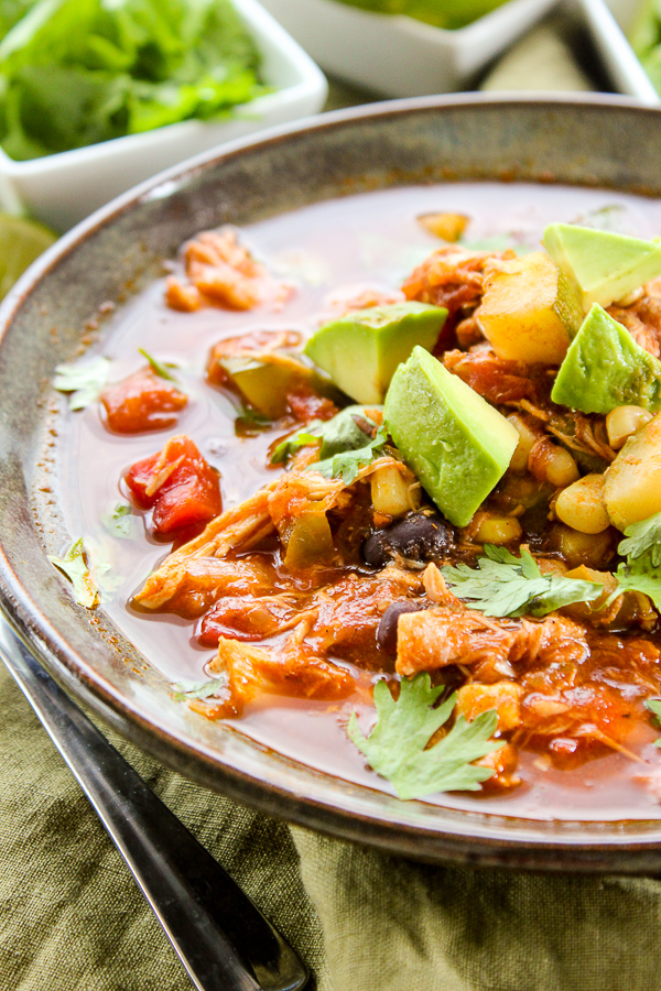 Two bean mexican chili served in a bowl and topped with avocado chunks