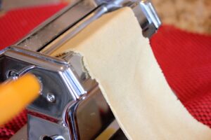 Showing dough as it's passing through the pasta maker for the first time.