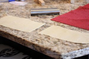 Showing the dough cut in half crosswise before continue to roll it out