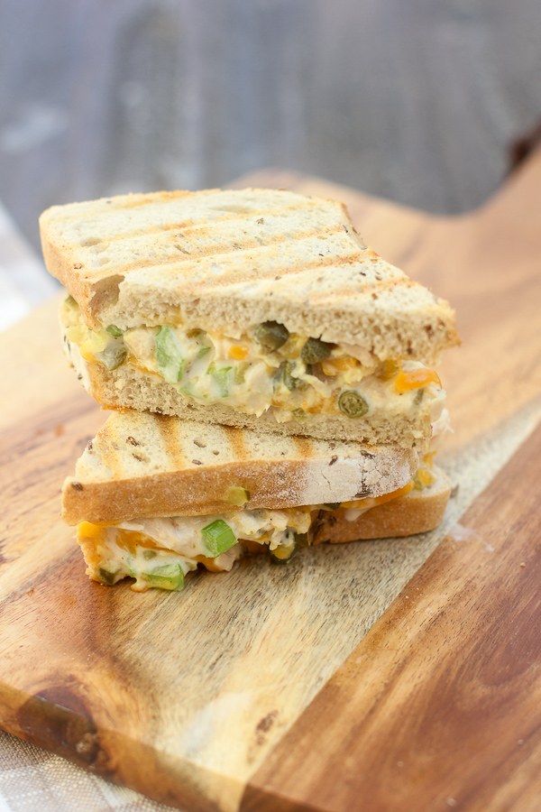 Panini on cutting board cut in half and stacked to show the filling