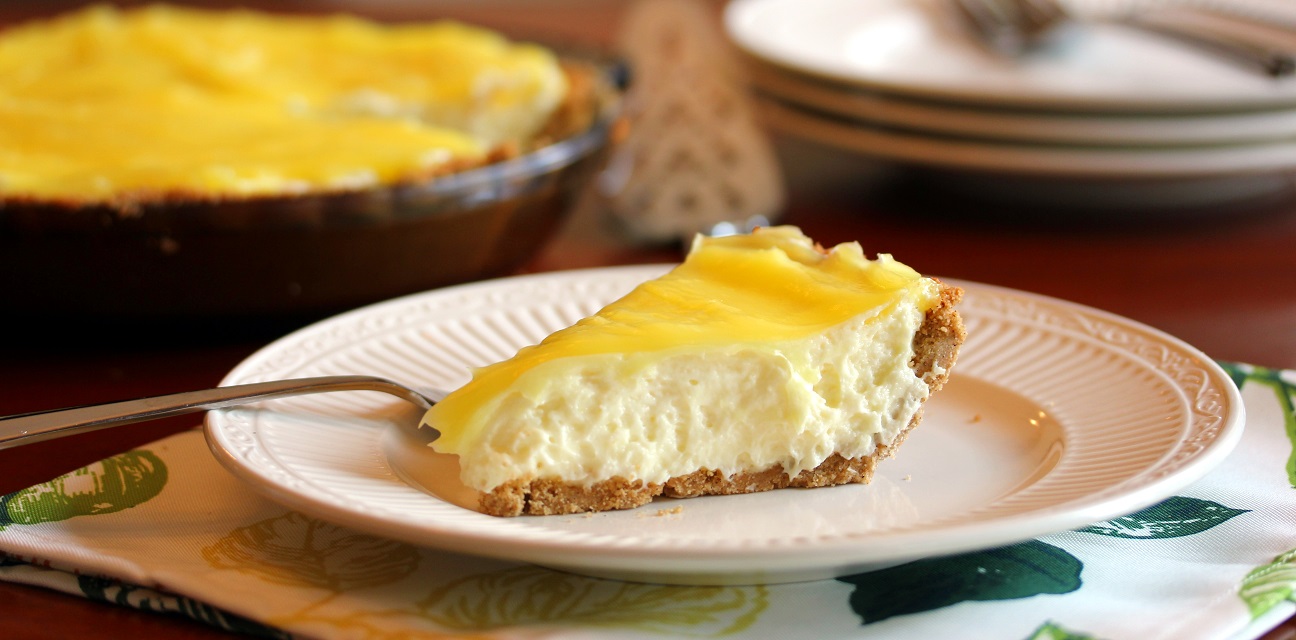 no bake lemon cream pie slice in the fore front with whole pie in the background