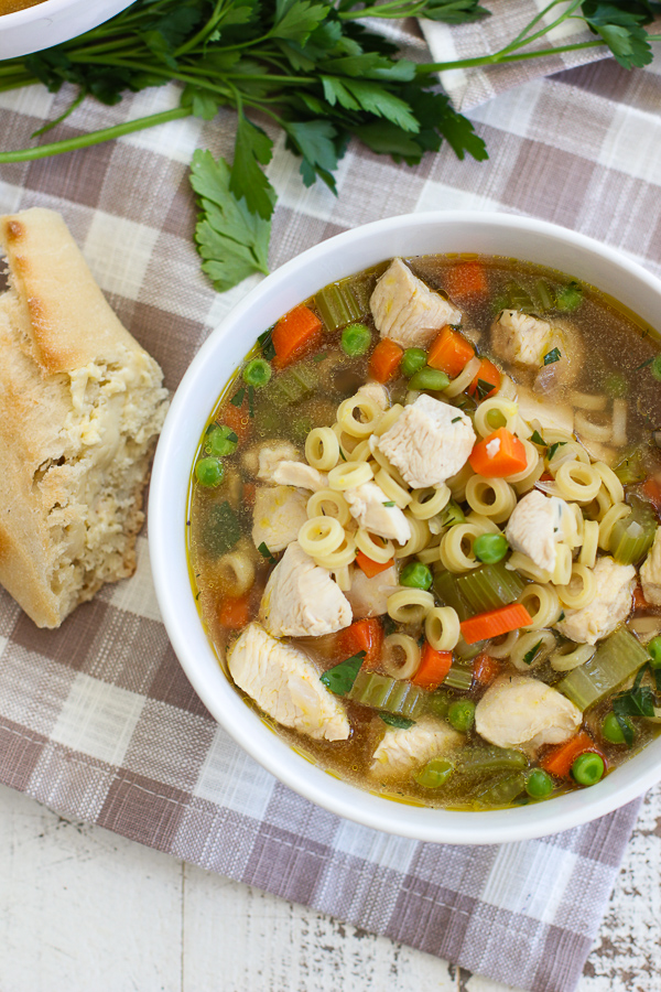 Lemon Dill Chicken Noodle Soup served in a bowl with crusty bread on the side.