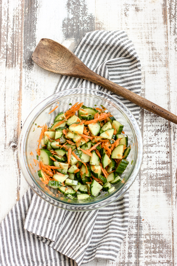 Asian style cucumber salad in the mixing bowl after tossing with the dressing