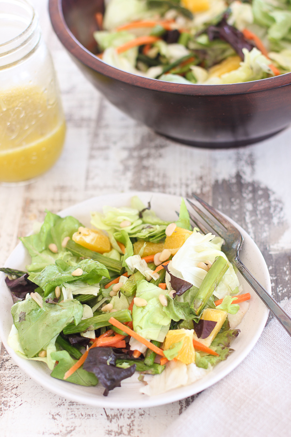 Roasted Asparagus Plated with the salad bowl and the dressing in the background