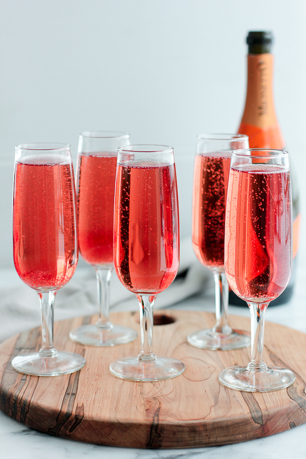 champagne cocktails in champagne flutes on a tray