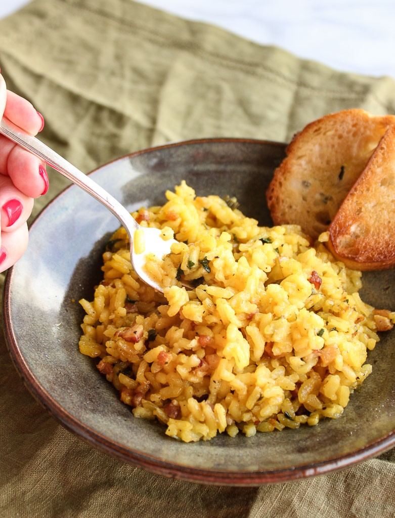 Risotto in a bowl with bread and a fork