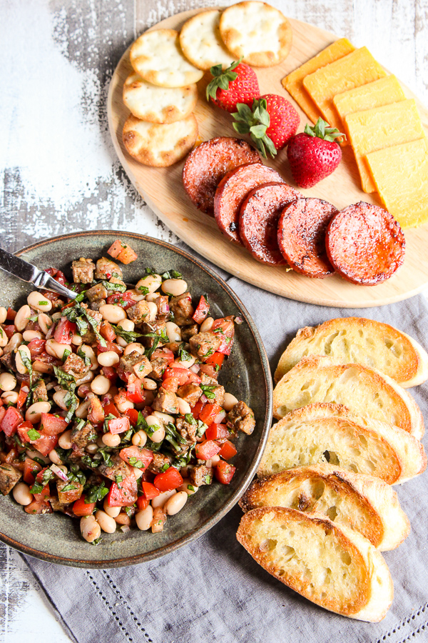 Italian sausage and white bean bruschetta in a serving bowl served with crostini