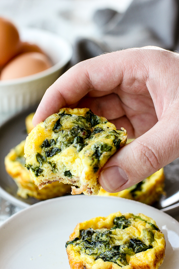 Holding one of the frittatas with a bite taken out of it