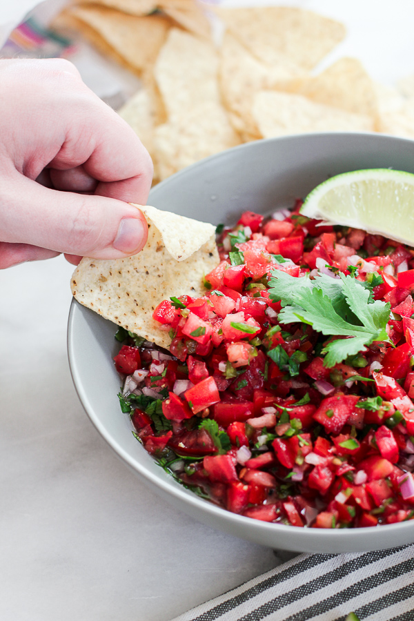 Dipping a chip into the pico de gallo